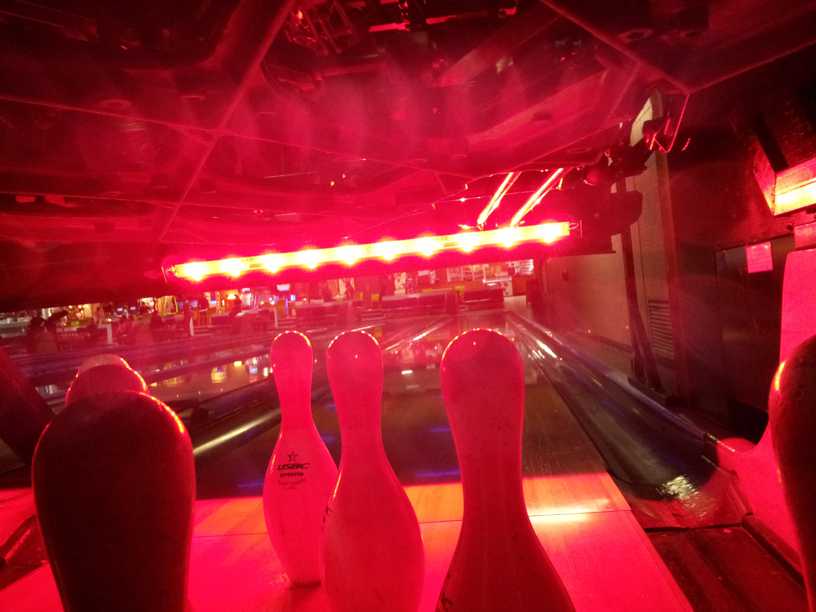 Photo - from behind the pins looking up the bowling lane red LED light